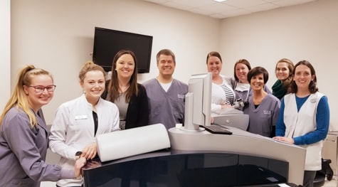 Wolfe Eye Clinic LASIK specialty team and Dr. Matthew Rauen stand next to all-laser LASIK technology in Des Moines, Iowa.