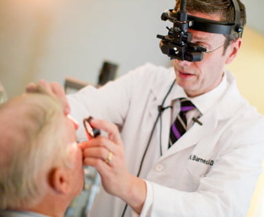 Wolfe Eye Clinic retina specialist, Dr. Charles Barnes, examines patient for retina disease in Cedar Rapids, Iowa.