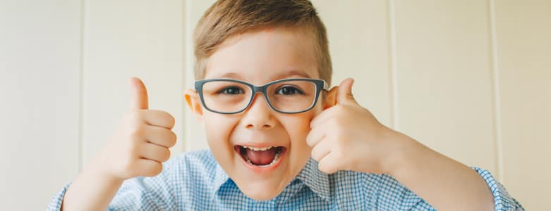 Happy child wearing glasses after childhood eye disorde