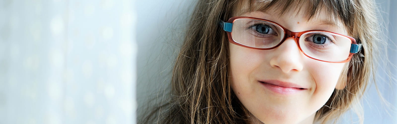 Little girl in glasses looking into the camera