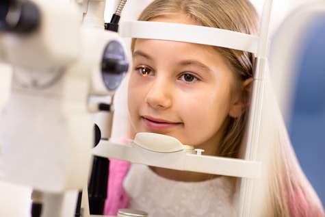 Child with childhood eye disorder having a tonometer eye exam with a pediatric ophthalmologist in Iowa.