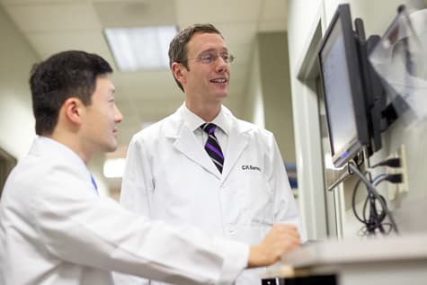 Wolfe Eye Clinic retina specialist, Dr. Charles Barnes, examines diabetic retinopathy vision testing results.