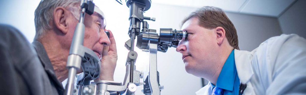 Doctor giving an elderly man a glaucoma test